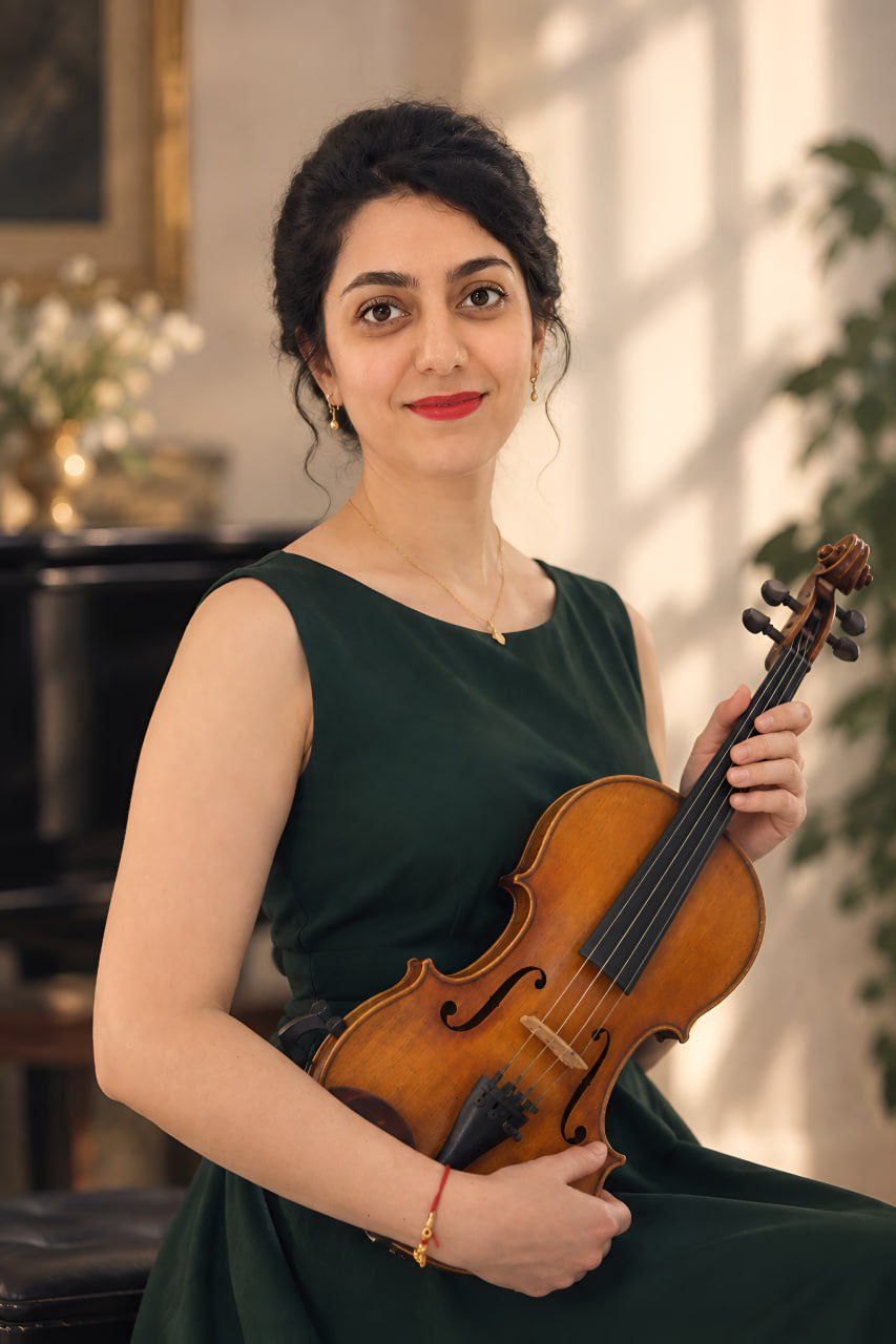 Mahshad Homaei smiling and holding her violin